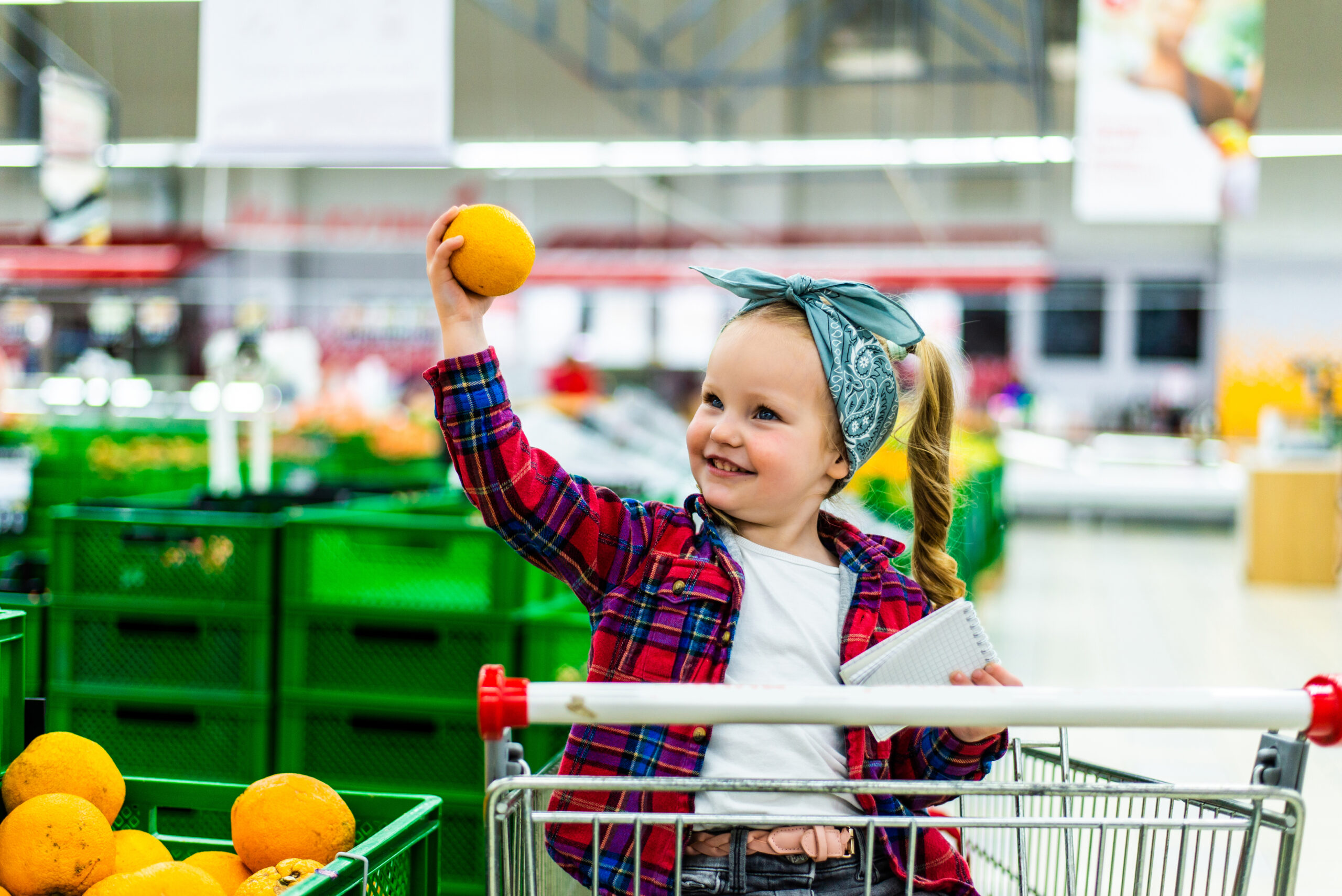 Little girl picking out oranges at the market